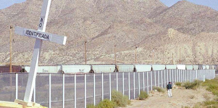 Una persona camina al lado de una sección del muro en la frontera entre México y Estados Unidos. (horizontal-x3)