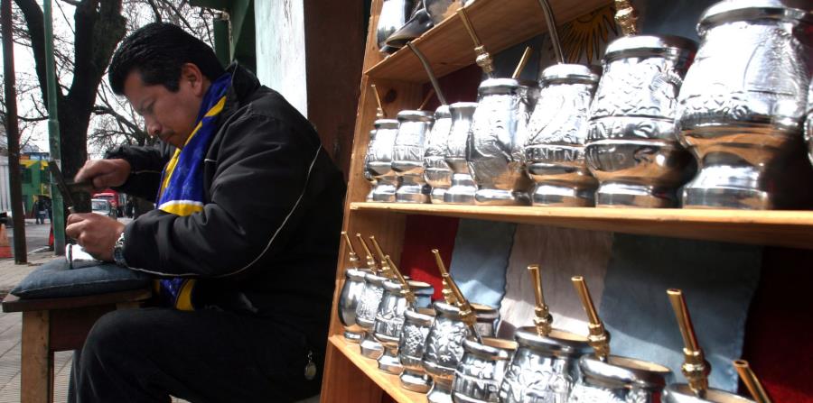 Un residente del sector boca, en Buenos Aires, marca unas tazas para tomar mate (horizontal-x3)