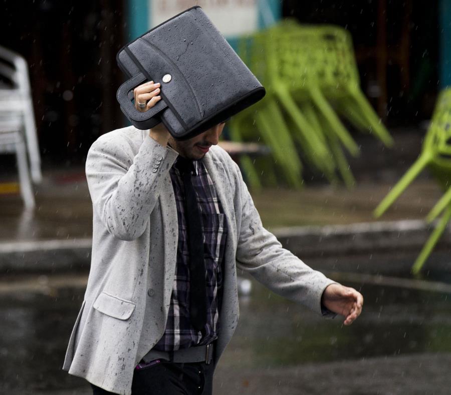 Un hombre se escuda con un portafolio de la lluvia. (GFR Media) (semisquare-x3)
