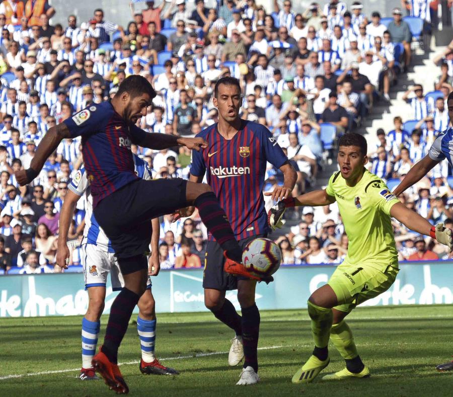 El delantero uruguayo Luis Suárez (izquierda) anota el primer gol del Barcelona en el partido contra la Real Sociedad, el sábado 15 de septiembre de 2018 en San Sebastián, España (semisquare-x3)
