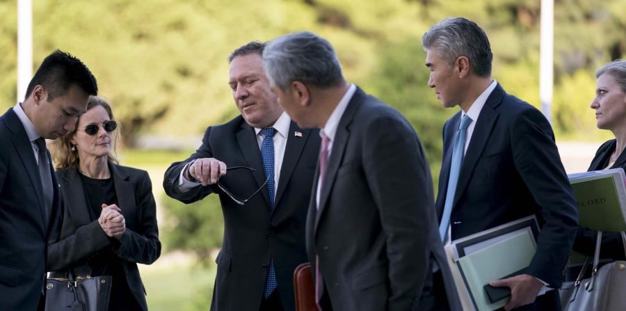 El secretario de Estado de Estados Unidos, Mike Pompeo, rodeado por funcionarios estadounidenses y norcoreanos, mira su reloj. (AP) (horizontal-x3)