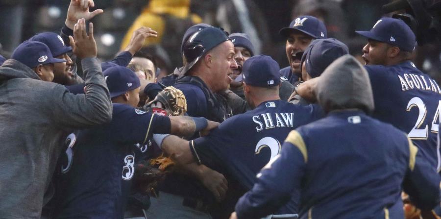 El receptor de los Cerveceros, Erik Kratz, es felicitado por sus compañeros de equipo tras el último out a los Rockies de Colorado. (AP) (horizontal-x3)