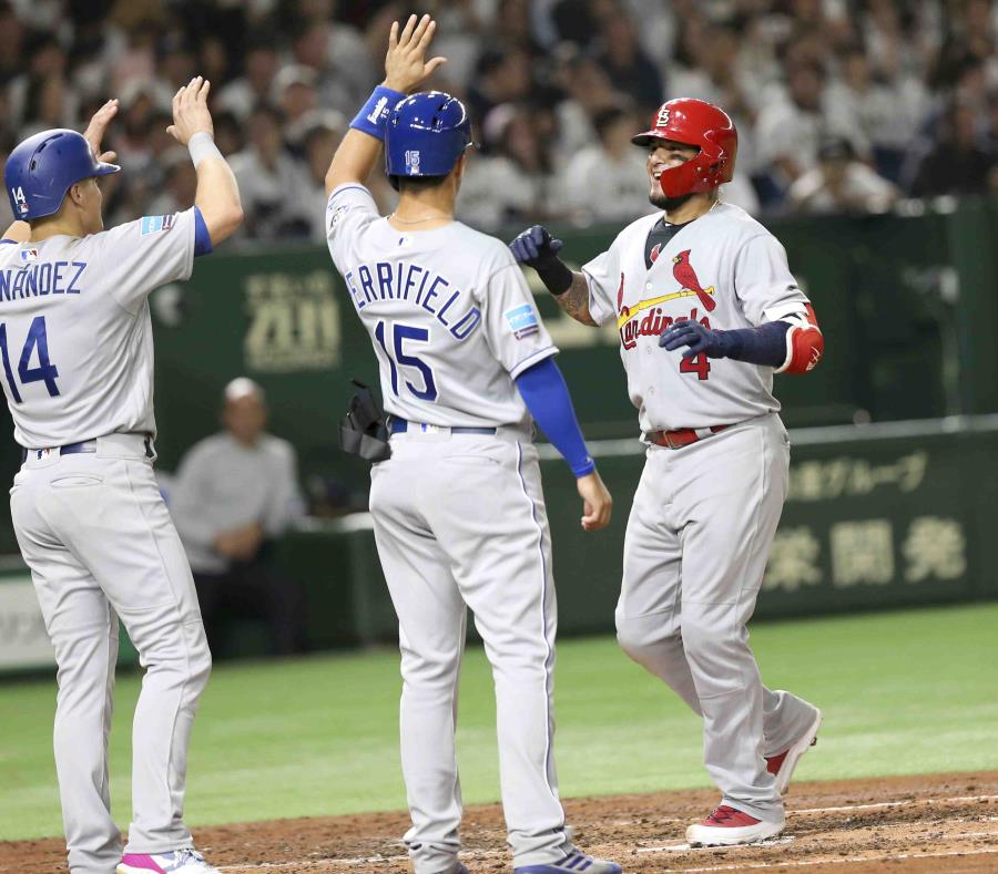 El receptor boricua Yadier Molina es felicitado en el plato por su compatriota, Enrique