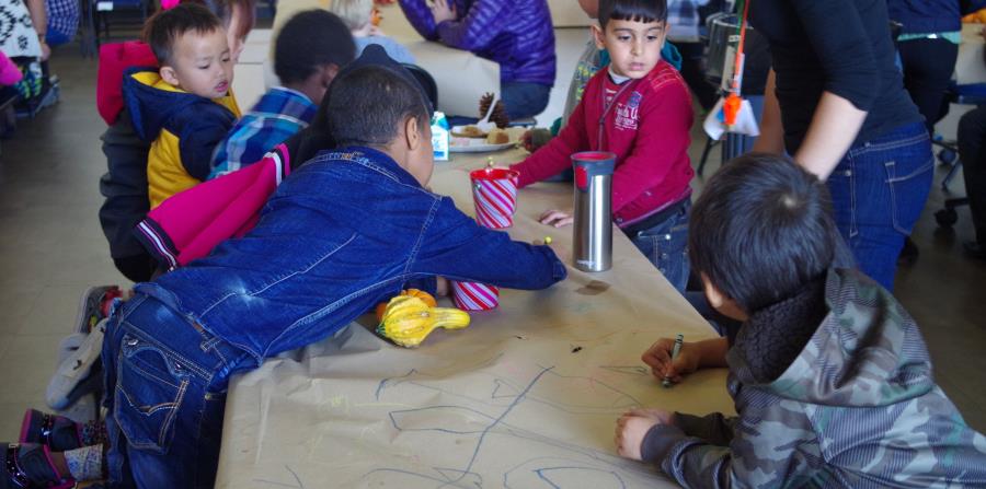 Unos niños inmigrantes de distintas razas juegan durante un almuerzo colectivo celebrado en la Escuela Comunitaria