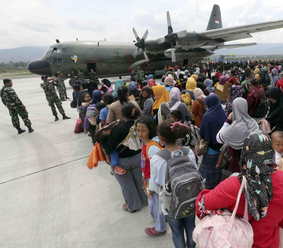 Un grupo de personas espera para embarcar en un avión de carga de la Fuerza Aérea en el aeropuerto Mutiara Sis Al-Jufri para salir de la ciudad de Palu, afectada por un sismo y un posterior tsunami, en el centro de la isla de Célebes, en Indonesia. (AP) (semisquare-x3)