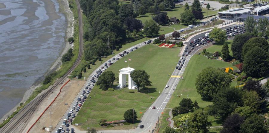 En esta fotografía de archivo del 24 de julio de 2009, varios vehículos hacen fila para cruzar hacia Estados Unidos, a la izquierda, y a Canadá, a la derecha, en la localidad canadiense de Boundary Bay, frente a Blaine, Washington. (AP) (horizontal-x3)