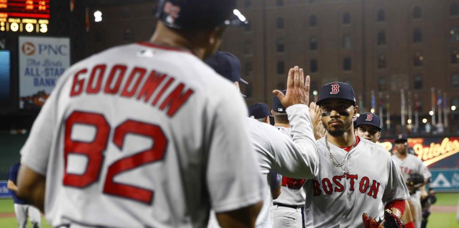 Mookie Betts choca manos con sus compañeros y coaches después del triunfo en Baltimore. (AP) (horizontal-x3)