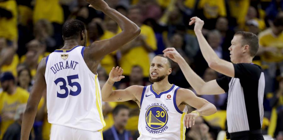 Kevin Durant y Stephen Curry, de los Warriors de Golden State, celebran una canasta. (AP) (horizontal-x3)