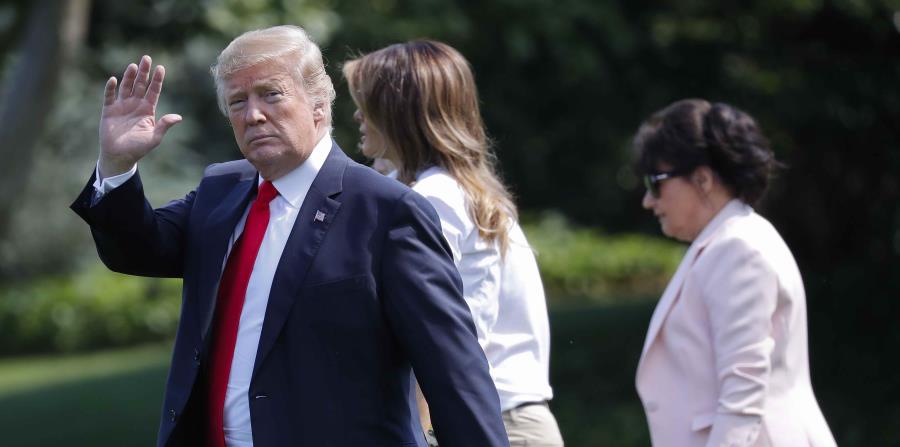El presidente Donald Trump, saluda a la gente mientras camina por el jardín de la Casa Blanca en Washington, acompañado de la primera dama Melania Trump, centro, y Amalija Knavs, derecha, madre de Melania Trump (horizontal-x3)