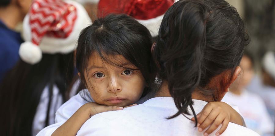 Lucia Quiej sostiene a su hija de cuatro años, Diana Jimenez, 4, en el marco de la campaña