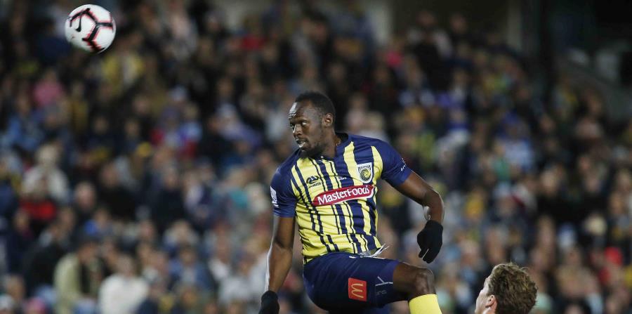 Bolt brinca para tratar de llegar al balón. (AP) (horizontal-x3)