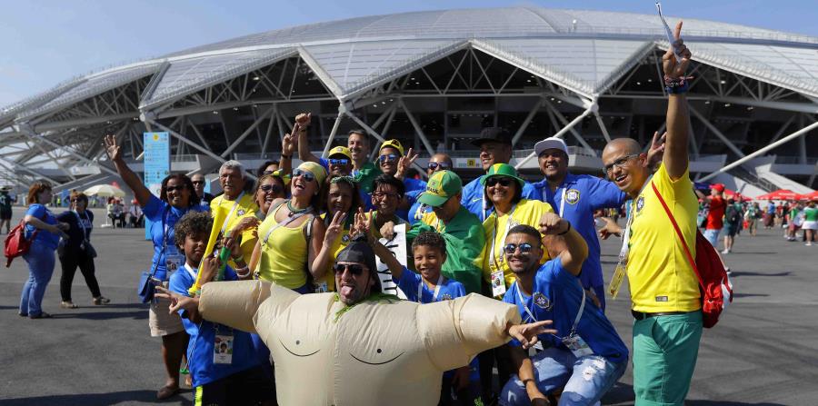 Hinchas brasileños posan frente a la Arena Samara previo al partido de octavos de final del Mundial entre México y Brasil, el lunes 2 de julio de 2018. (AP) (horizontal-x3)