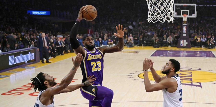 LeBron james intenta un canasto ante Derrick Rose y Karl Anthony Towns. (AP) (horizontal-x3)