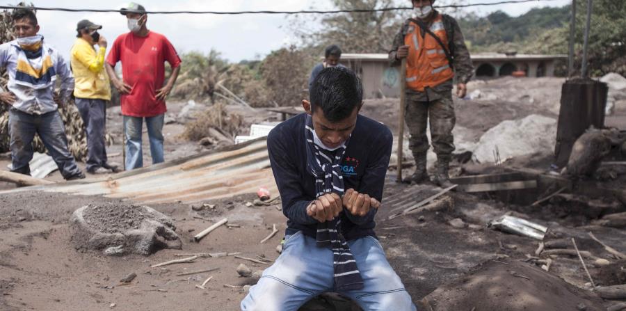 Bryan Rivera llora al ver los restos de su casa, después de que su familia desapareciera en la erupción del Volcán de Fuego en San Miguel Los Lotes, Guatemala. (horizontal-x3)