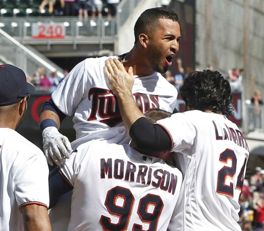 El boricua Eddie Rosario es felicitado por sus compañeros de equipo luego de conectar el cuadrangular de la victoria para los Mellizos de Minnesota. (AP / Jim Mone) (semisquare-x3)