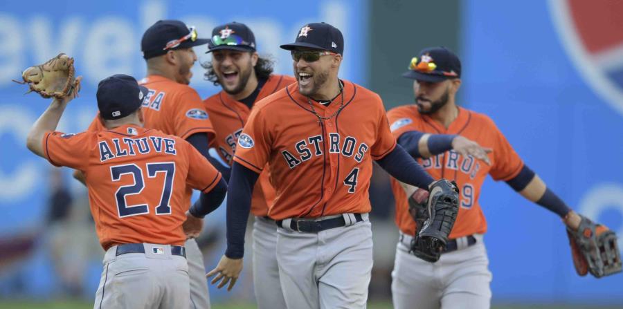 Los jugadores de los Astros de Houston George Springer (4) y el venezolano José Altuve se felicitan, mientras sus compañeros empiezan la celebración luego de vencer a los Indios de Cleveland. (AP / David Dermer) (horizontal-x3)