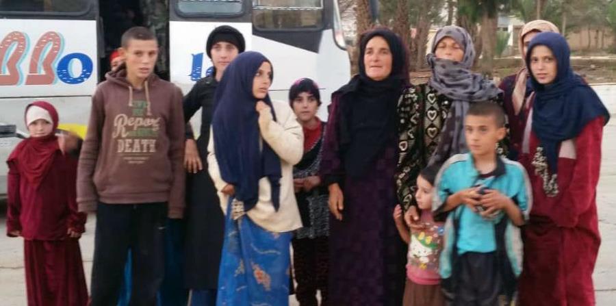 En esta imagen, distribuida por la agencia oficial de noticias de Siria, SANA, mujeres y niños liberados del grupo extremista Estados Islámico en Hamima, al este de la histórica ciudad de Palmora, en Siria, el 8 de noviembre de 2018. (horizontal-x3)