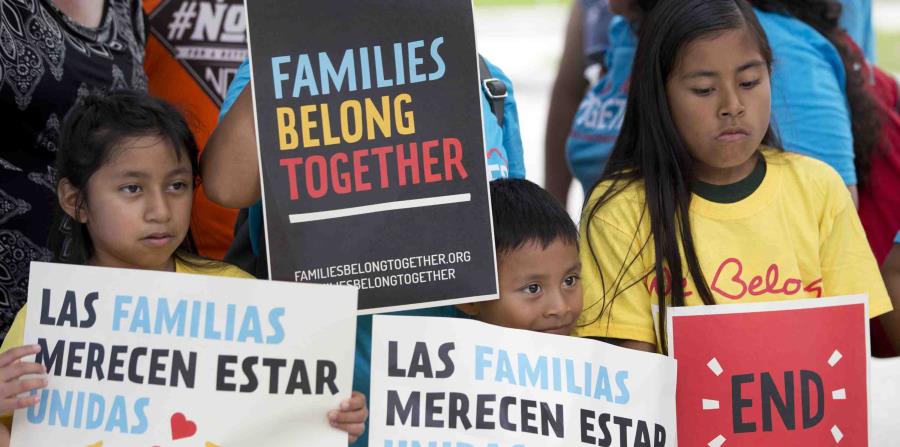 niños sosteniendo carteles durante una manifestación enfrente de la oficina del Servicio de Control de Inmigración y Aduanas en Miramar, Florida. (AP (horizontal-x3)