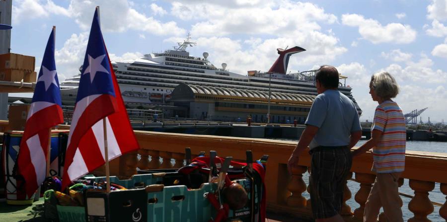 dos turistas paseando frente a un crucero en el Puerto de San Juan (horizontal-x3)
