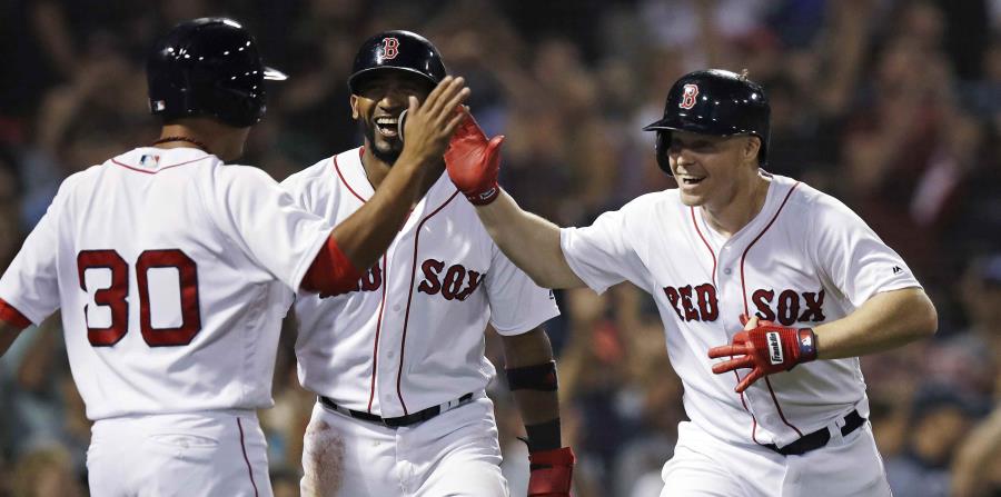Brock Holt (extrema derecha) es felicitado luego de anotar una carrera por sus compañeros de los Medias Rojas Tzu-Wei Lin (30) y Eduardo Núñez (centro). (AP / Charles Krupa) (horizontal-x3)