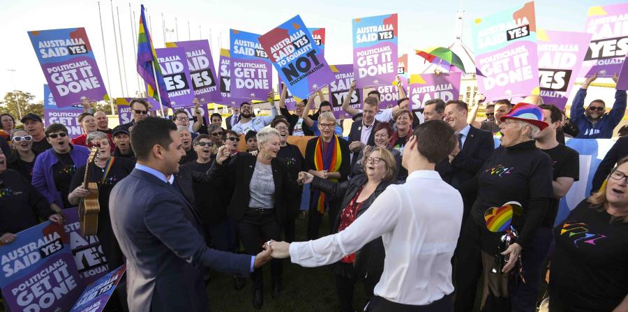 Activistas y voluntarios paritdarios del matrimonio homosexual corean lemas mientras piden a los legisladores que modifiquen la ley para legalizar el matrimonio homosexual, en una marcha ante el Parlamento en Canberra, Australia (horizontal-x3)