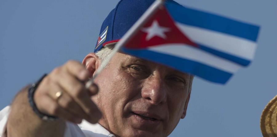 El presidente cubano, Miguel Diaz-Canel, muestra una bandera de Cuba. (AP) (horizontal-x3)