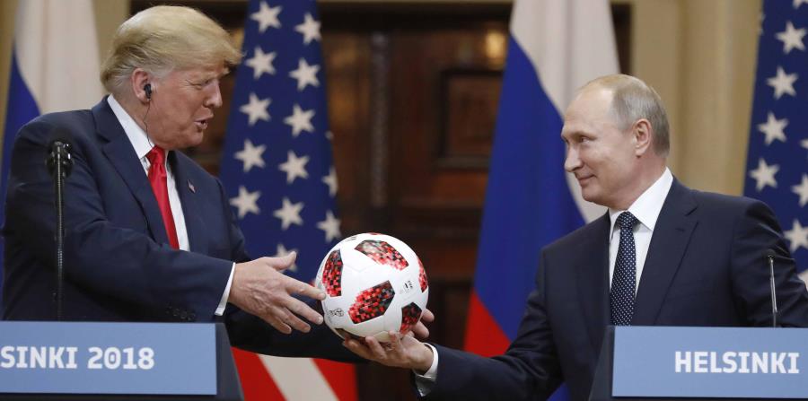 Trump recibe un balón de fútbol de manos del presidente ruso Vladimir Putin. (AP) (horizontal-x3)