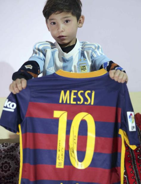 Murtaza Ahmadi, aficionado de Lionel Messi, muestra el autógrafo del astro argentino en una camiseta en la casa de unos familiares en Kabul, Afganistán el viernes 7 de diciembre de 2018. (AP) (vertical-x1)