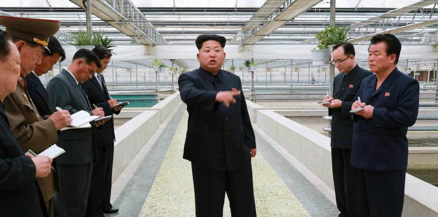 El líder norcoreano Kim Jong-un (al centro) durante una visita a una fábrica en un lugar sin identificar en Corea del Norte. (EFE) (horizontal-x3)