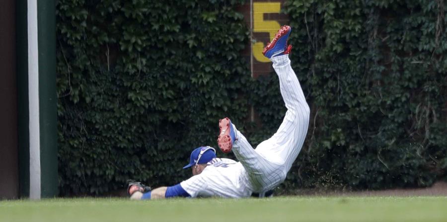 El jardinero izquierdo Ian Happ, de los Cachorros, se lanza al terreno para atrapar el último out del partido contra los Piratas. (AP) (horizontal-x3)