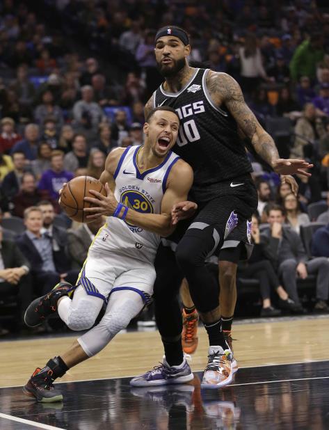 El jugador de los Warriors de Golden State, Stephen Curry (izquierda), maneja el balón ante su rival de los Kings de Sacramento, Willie Cauley-Stein. (AP) (vertical-x1)