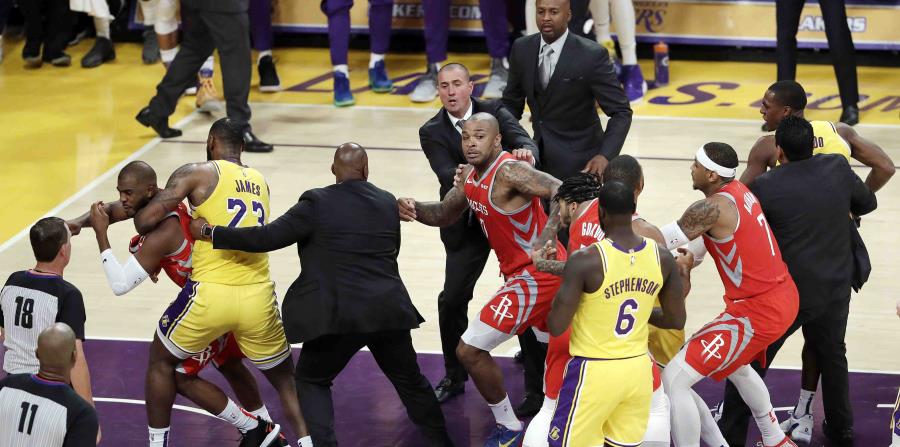 Chris Paul, de los Rockets de Houston, a la izquierda, es sujetado por LeBron James, de Los Lakers de Los Ángeles, después de una pelea con Rajon Rondo, de los Lakers, en la segunda mitad del juego del sábado. (AP / Marcio José Sánchez) (horizontal-x3)