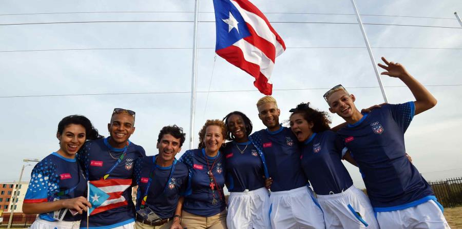 Parte de la delegación de Puerto Rico posa junto a la bandera a pocos días de los Juegos Centroamericanos y del Caribe. (horizontal-x3)