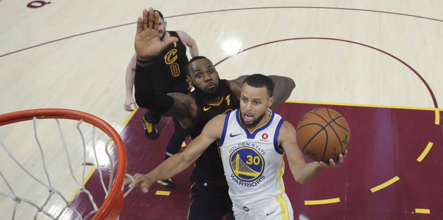 LeBron James, de los Cavaliers de Cleveland, intenta evitar que Stephen Curry, de los Warriors de Golden State, enceste. (AP) (horizontal-x3)