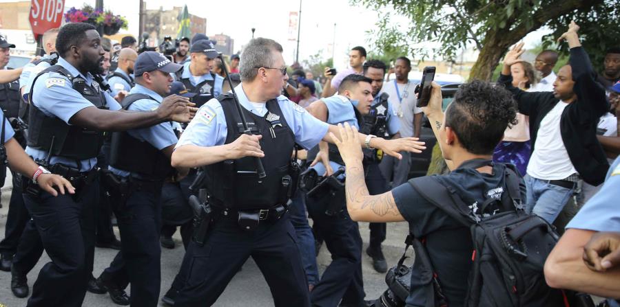 Agentes del Departamento de Policía de Chicago confrontan a una multitud enargdecida tras la muerte a tiros de un hombre a manos de agentes en Chicago, el sábado 14 de julio de 2018. (AP) (horizontal-x3)