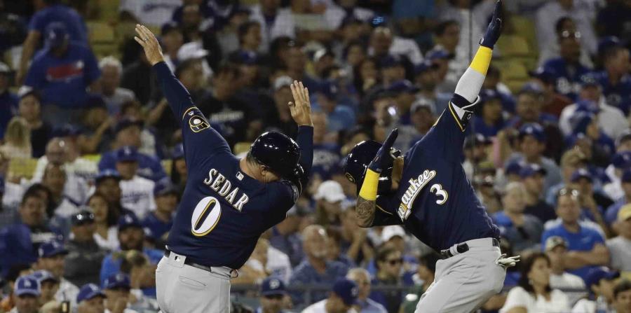 Orlando Arcia (der.) celebra su cuadrangular de dos carreras con el coach de tercera de los Cerveceros de Milwaukee, Ed Sedar. (AP / Matt Slocum) (horizontal-x3)