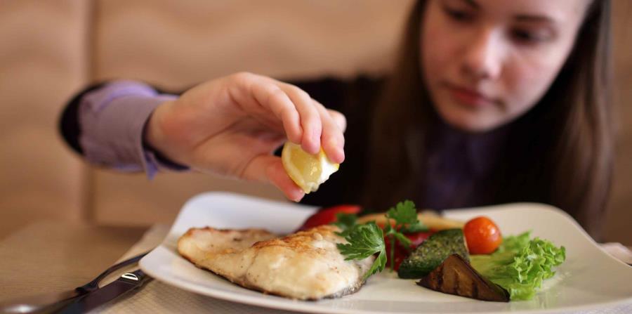 Joven comiendo pescado. (horizontal-x3)