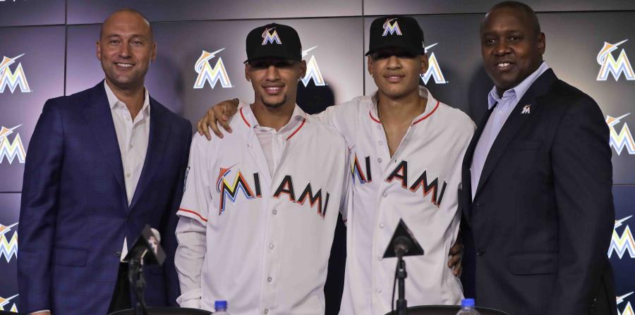 El director general de los Marlins de Miami, Derek Jeter, (de izquierda a derecha) posa con Víctor Víctor Mesa, Víctor Mesa Jr., y Michael Hill, presidente de operaciones de béisbol, durante una conferencia de prensa. (AP) (horizontal-x3)