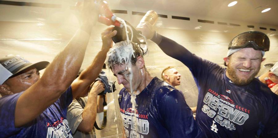 Los jugadores de los Dodgers de Los Ángeles celebran en el camerino al vencer a los Rockies de Colorado, triunfo que les garantizó el banderín de la División Oeste de la Liga Nacional. (AP) (horizontal-x3)