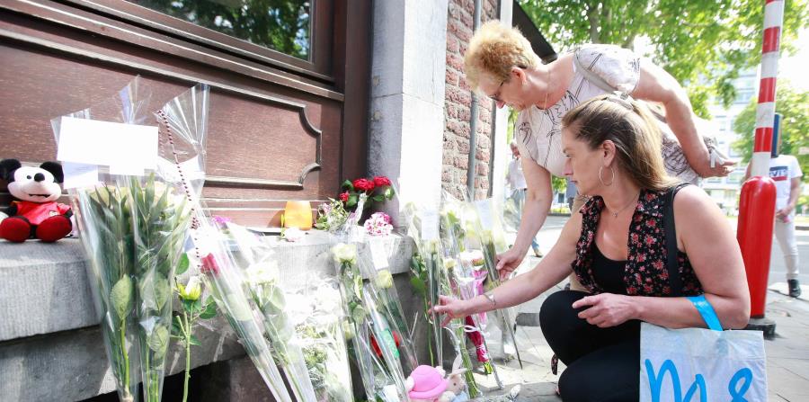 Varias personas colocan flores como homenaje a las víctimas del tiroteo de ante el Café 'Les Augustins', de Lieja, Bélgica (horizontal-x3)