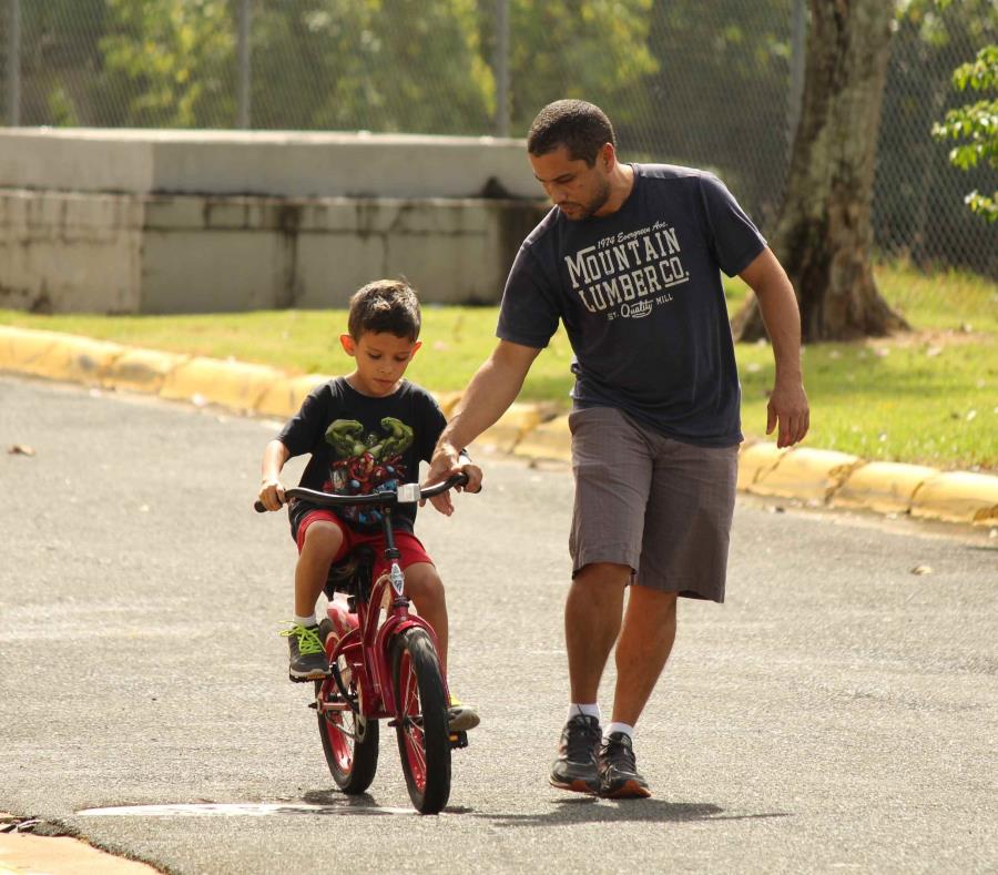 Un joven enseña a un niño a correr bicicleta. (Suministrada) (semisquare-x3)
