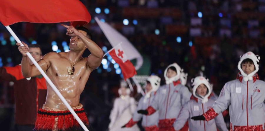 Pita Taufatofua lideró su delegación con el torso al descubierto untado de aceite y protegiéndose tan sólo con una falda tradicional de tela, mientras los otros asistentes se cubrían del gélidoclima. (AP) (horizontal-x3)