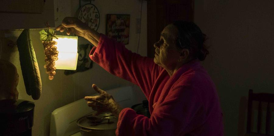 Marta Bermúdez Robles, de 66 años, cuelga una lámpara en su cocina, en Adjuntas, Puerto Rico, ante la falta de electricidad desde el paso de los huracanes Irma y María. (horizontal-x3)