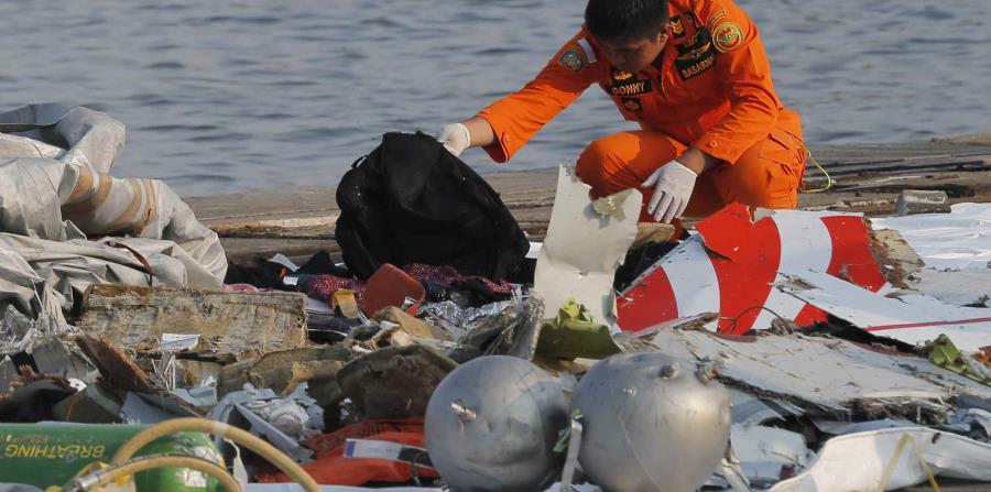 Un empleado inspecciona los artículos encontrados en altamar. (AP) (horizontal-x3)