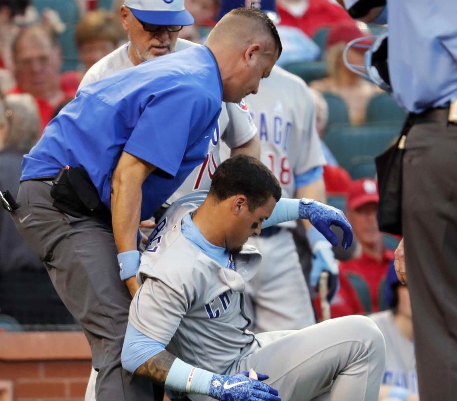 Javier Báez es ayudado por un integrante del personal técnico de los Cachorros después de recibir el pelotazo. (AP) (semisquare-x3)