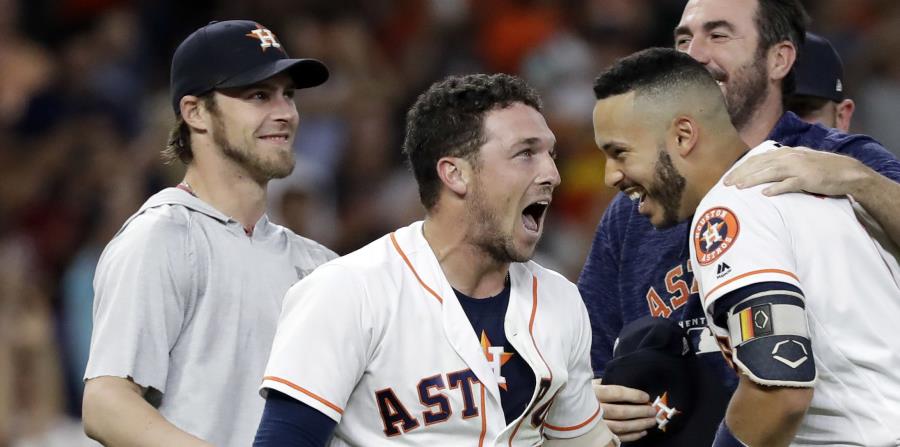 El jugador de los Astros de Houston, Alex Bregman, centro, celebra con Carlos Correa y el resto de sus compañeros luego de conectar un doble productor de dos carreras para darle la victoria a su equipo contra los Rays de Tampa Bay, durante el noveno innin (horizontal-x3)