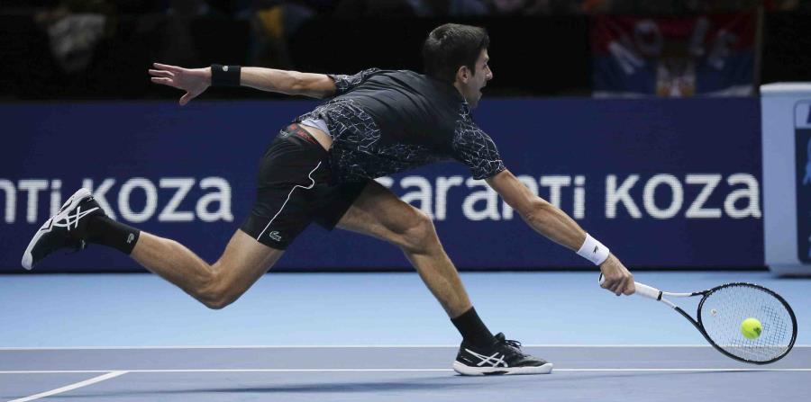 Novak Djokovic devuelve un tiro de John Isner durante su enfrentamiento en la Copa Masters. (AP / Tim Ireland) (horizontal-x3)