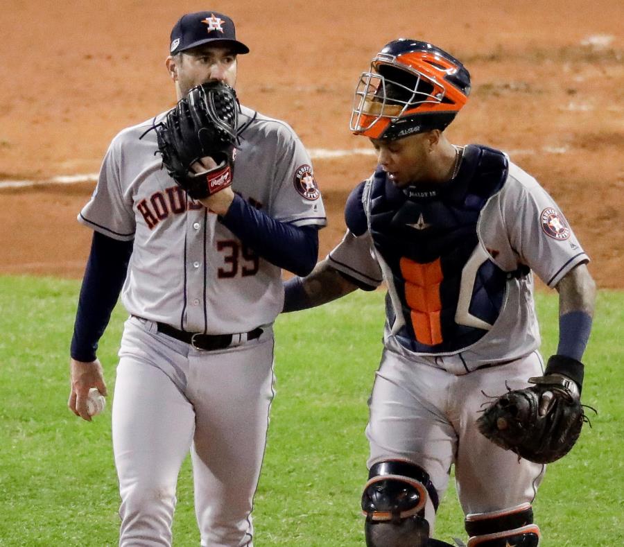 El boricua Martín “Machete” Maldonado (derecha) conversa con el lanzador Justin Verlander durante el primer partido de la serie. (AP / Elise Amendola) (semisquare-x3)