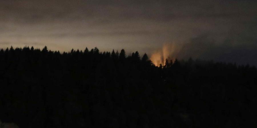 Esta foto del sábado, 11 de agosto del 2018 se ven humo y un resplandor naranja sobre la isla Ketron, en el estado de Washington. (AP) (horizontal-x3)