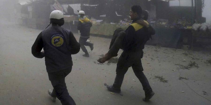 Personal del grupo Defensa Civil Siria, conocido como Cascos Blancos, trasladan a un herido después de los ataques aéreos contra un suburbio en poder de los rebeldes cerca de Damasco, en Siria (horizontal-x3)